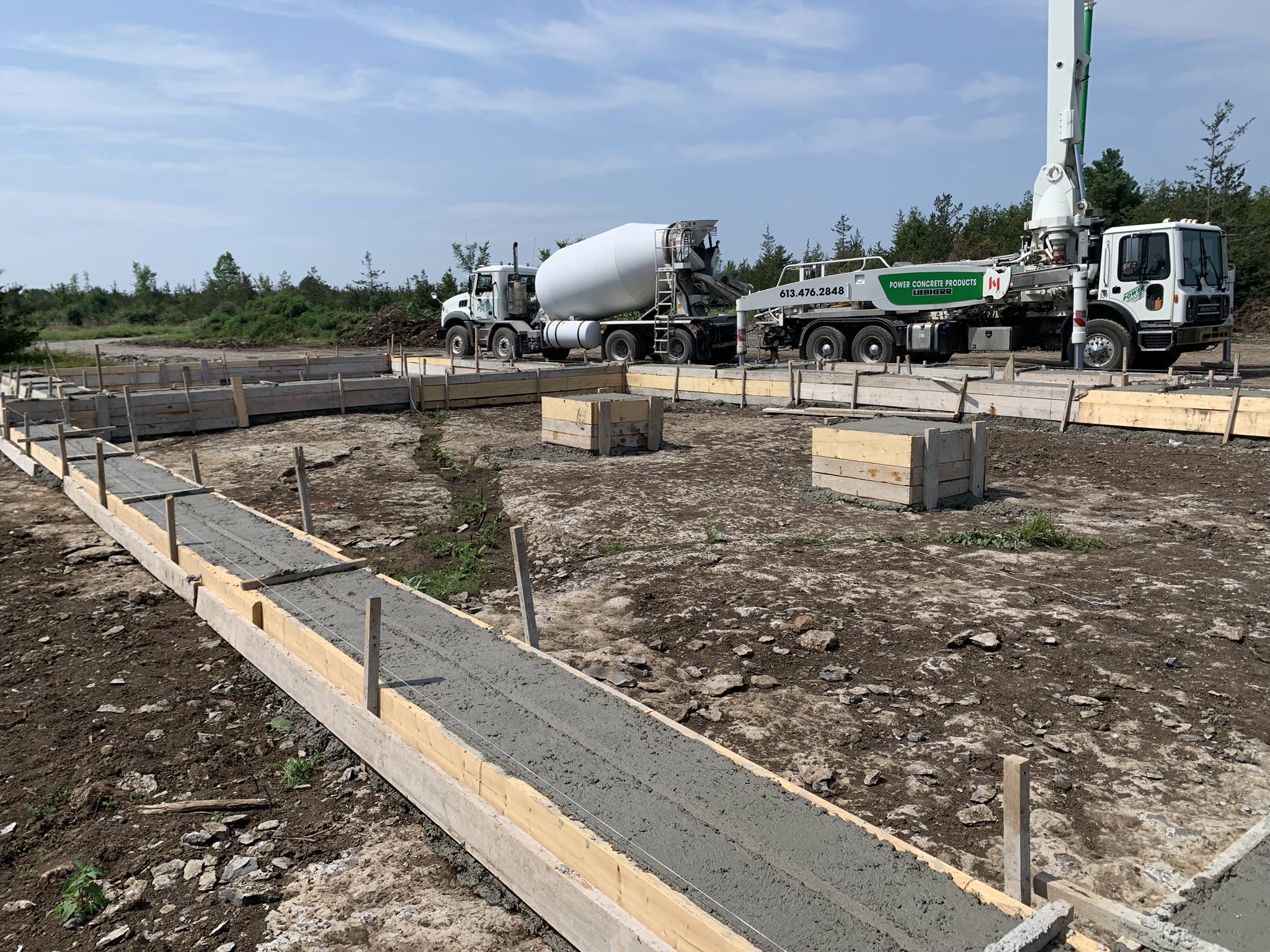 Power Concrete mixer and boom pump pouring a foundation