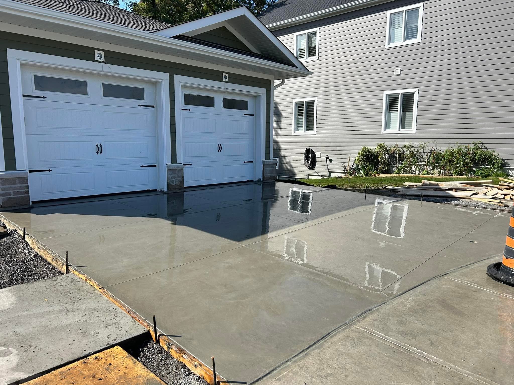 Freshly finished concrete driveway in front of a home