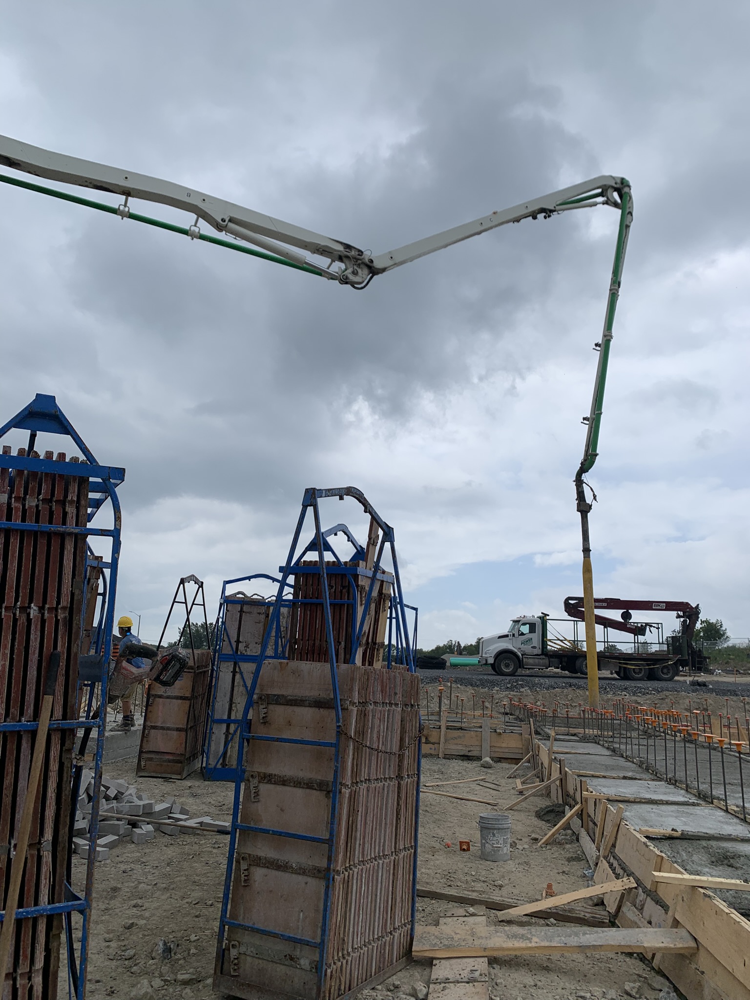 Concrete boom pump reaching over foundation formwork